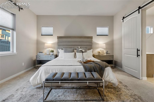 bedroom featuring a barn door, carpet, and multiple windows