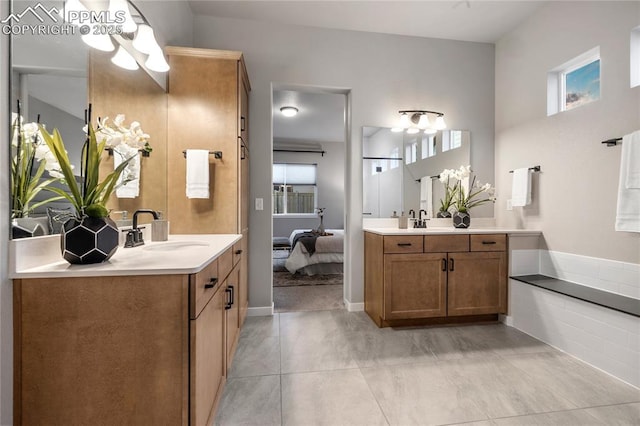 bathroom with a chandelier, tile patterned flooring, two vanities, and connected bathroom