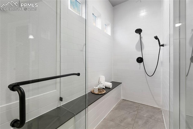full bath with a tile shower and tile patterned floors