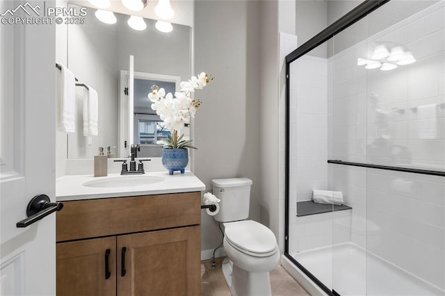 full bathroom featuring a stall shower, toilet, and vanity
