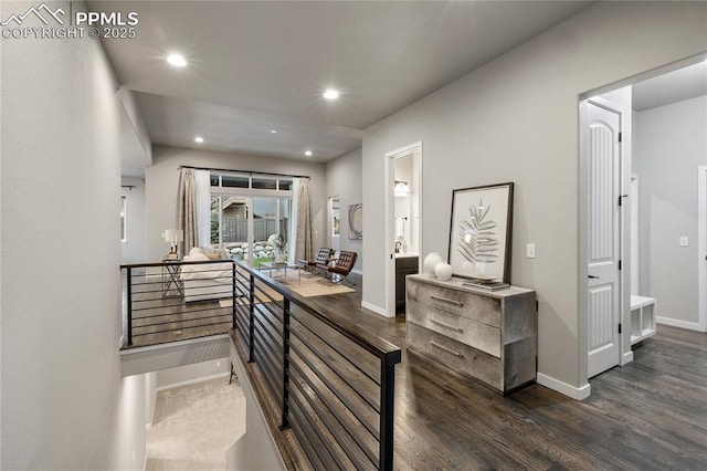 hall with dark wood-style flooring, baseboards, and recessed lighting