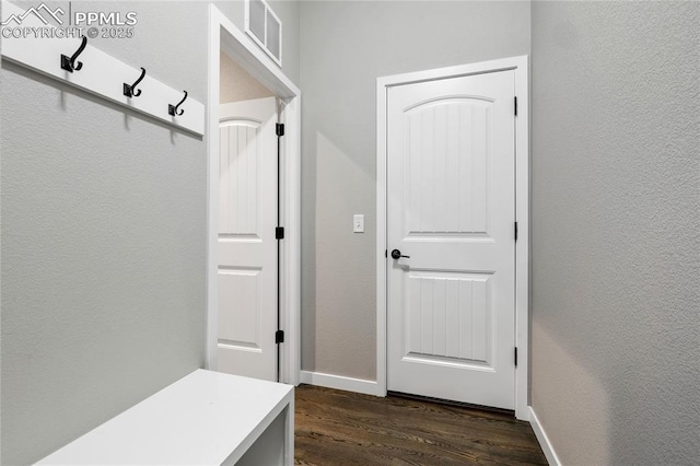 mudroom featuring dark wood-style floors, baseboards, and a textured wall