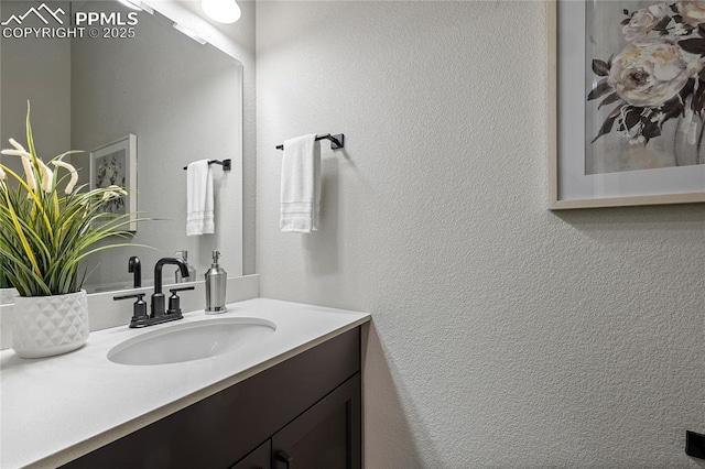 bathroom with a textured wall and vanity