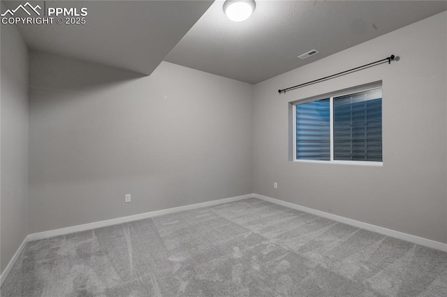 spare room featuring carpet flooring and baseboards