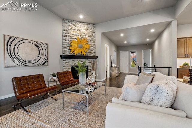 living room featuring dark wood-style flooring, baseboards, recessed lighting, and a fireplace