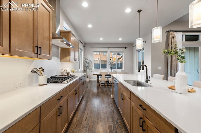 kitchen featuring a sink, stainless steel appliances, wall chimney exhaust hood, dark wood finished floors, and recessed lighting