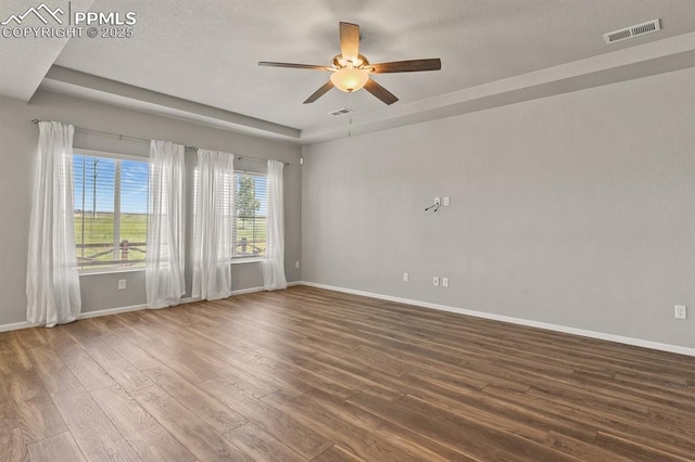 7238 Fauna Glen Dr, Colorado Springs, CO 80927 - unfurnished room with wood finished floors, ceiling fan, and a tray ceiling
