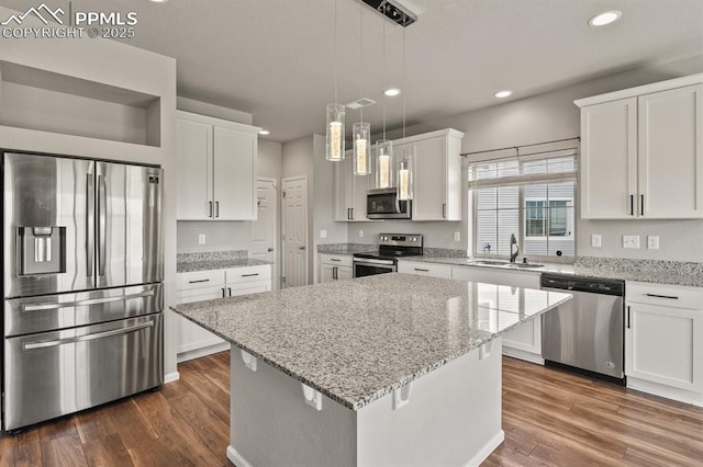 7238 Fauna Glen Dr, Colorado Springs, CO 80927 - kitchen with appliances with stainless steel finishes, white cabinets, a kitchen island, recessed lighting, and dark wood-style flooring