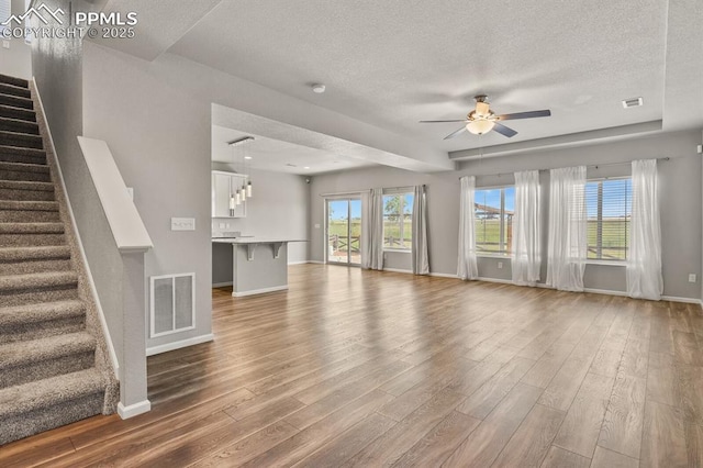7238 Fauna Glen Dr, Colorado Springs, CO 80927 - unfurnished living room with ceiling fan, wood finished floors, a textured ceiling, and stairs