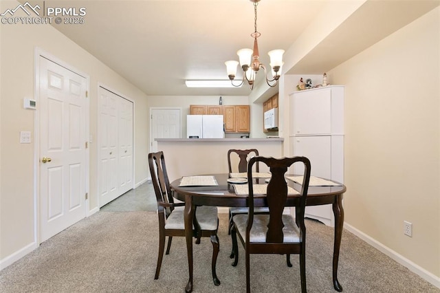 dining area featuring a chandelier, carpet floors, and baseboards