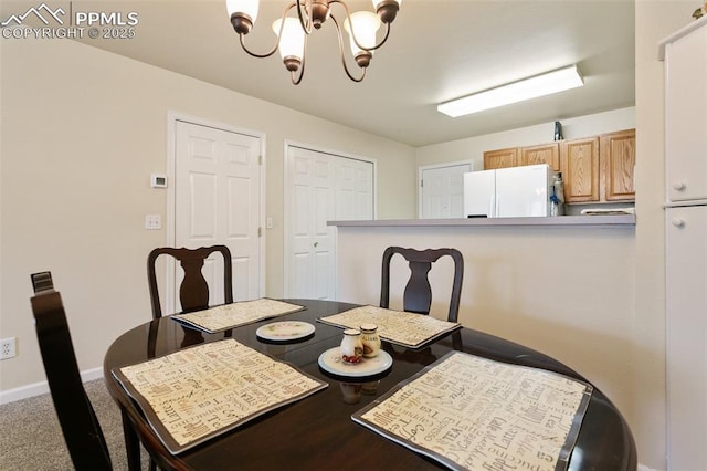 dining room featuring a chandelier and baseboards