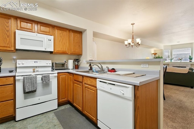 kitchen featuring white appliances, a peninsula, a sink, a chandelier, and open floor plan