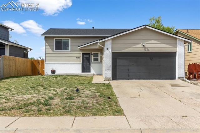4650 Cassidy St, Colorado Springs, CO 80911 - view of front of home with driveway, brick siding, fence, an attached garage, and a front yard