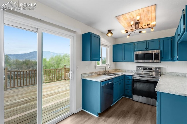 4650 Cassidy St, Colorado Springs, CO 80911 - kitchen with a mountain view, an inviting chandelier, a sink, blue cabinetry, and stainless steel appliances