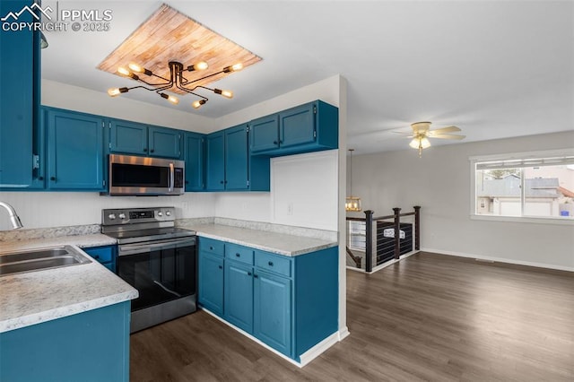 4650 Cassidy St, Colorado Springs, CO 80911 - kitchen with stainless steel appliances, dark wood-style flooring, a sink, blue cabinetry, and light countertops