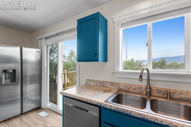 4650 Cassidy St, Colorado Springs, CO 80911 - kitchen featuring a sink, blue cabinets, light wood finished floors, light countertops, and appliances with stainless steel finishes