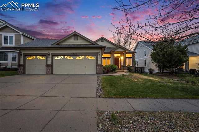 view of front of property featuring brick siding, an attached garage, a front lawn, and concrete driveway