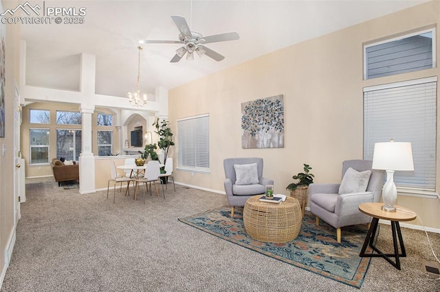 sitting room with a ceiling fan, carpet flooring, a chandelier, baseboards, and high vaulted ceiling