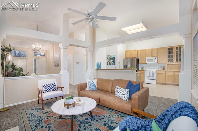 living room featuring high vaulted ceiling, a chandelier, baseboards, a ceiling fan, and light carpet
