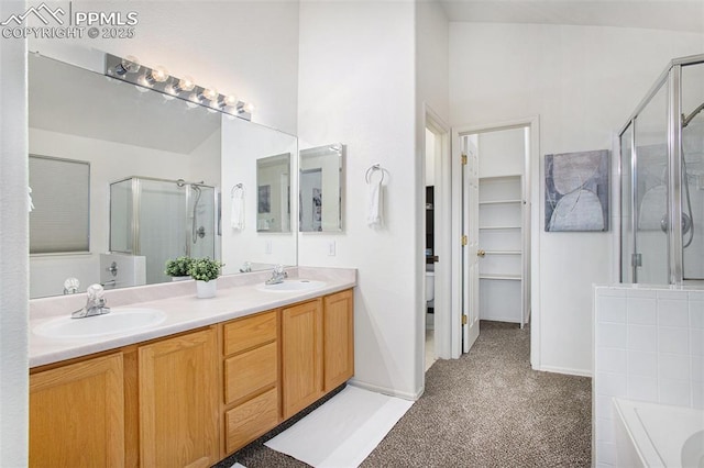 bathroom with a stall shower, a garden tub, double vanity, and a walk in closet