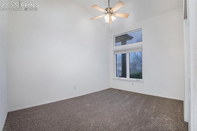 carpeted spare room featuring vaulted ceiling, ceiling fan, and baseboards