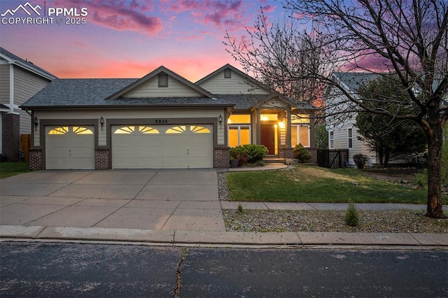 traditional home featuring an attached garage, brick siding, a front lawn, concrete driveway, and a shingled roof