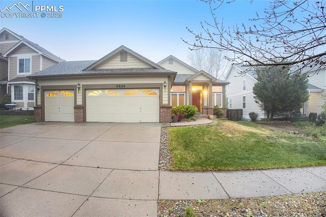 view of front facade with brick siding, a garage, a front yard, concrete driveway, and a shingled roof