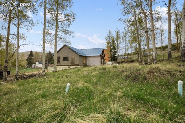 910 Victor Ave, Goldfield, CO 80860 - view of side of property with metal roof, a mountain view, and a chimney