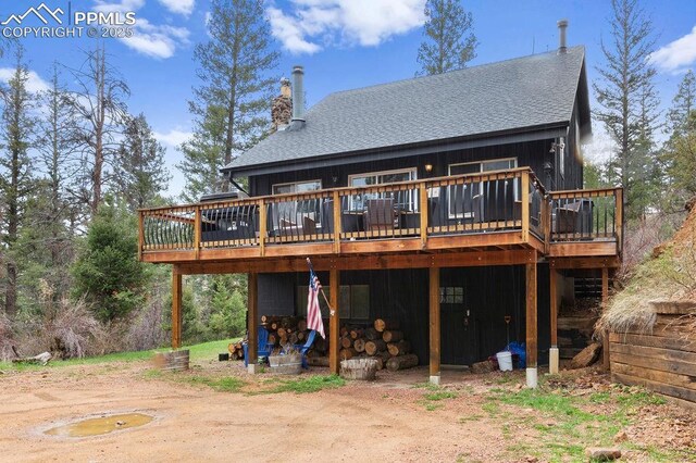 9410 Shoshone Rd, Cascade, CO 80809 - rear view of property with a shingled roof, a wooden deck, and a chimney