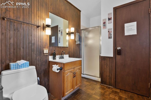 9410 Shoshone Rd, Cascade, CO 80809 - full bath featuring wood walls, a stall shower, toilet, vanity, and baseboard heating