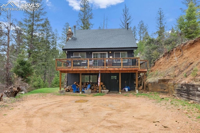 9410 Shoshone Rd, Cascade, CO 80809 - rear view of house featuring a wooden deck and a chimney