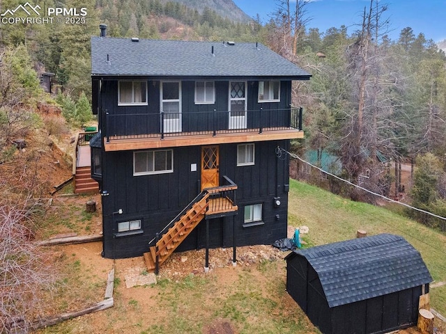9410 Shoshone Rd, Cascade, CO 80809 - rear view of property with stairway, board and batten siding, and a balcony