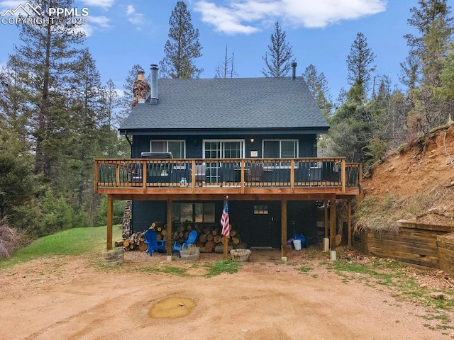 9410 Shoshone Rd, Cascade, CO 80809 - back of property with a deck and a chimney