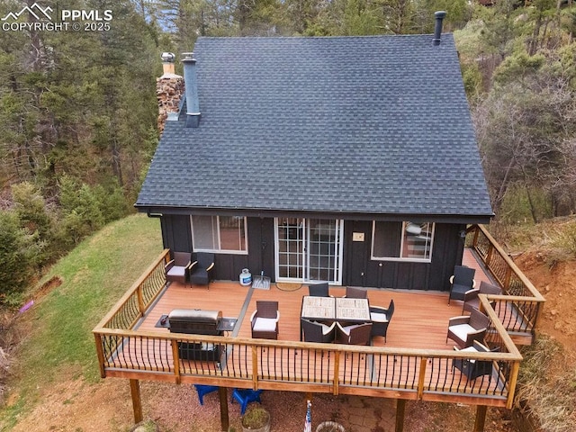 9410 Shoshone Rd, Cascade, CO 80809 - back of property with board and batten siding, outdoor lounge area, a deck, a chimney, and roof with shingles