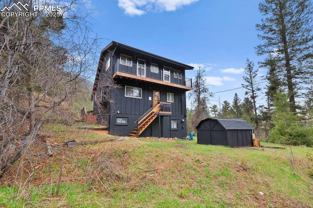 9410 Shoshone Rd, Cascade, CO 80809 - back of house with a balcony, a shed, stairs, an outdoor structure, and board and batten siding