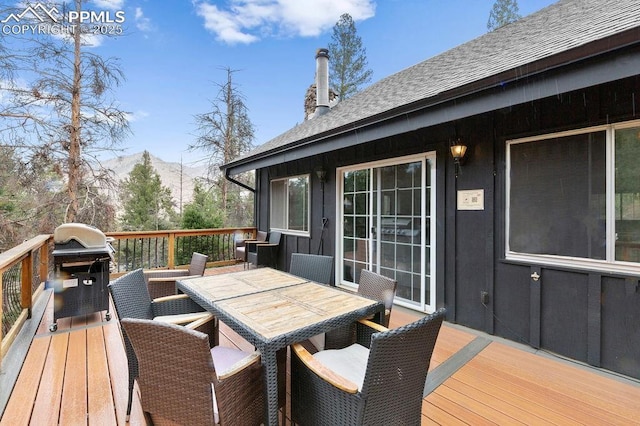 9410 Shoshone Rd, Cascade, CO 80809 - wooden terrace featuring outdoor dining area, a mountain view, and grilling area