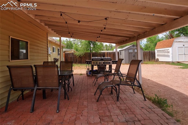 105 Easy St, Colorado Springs, CO 80911 - view of patio featuring a shed, outdoor dining space, a fenced backyard, and an outbuilding