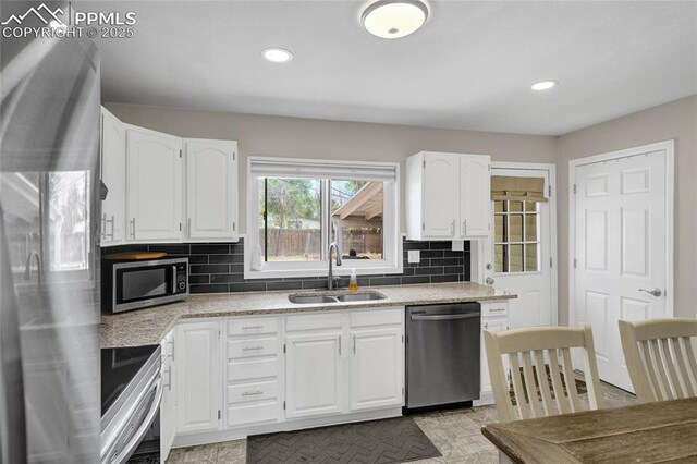 105 Easy St, Colorado Springs, CO 80911 - kitchen featuring appliances with stainless steel finishes, a sink, white cabinetry, backsplash, and recessed lighting