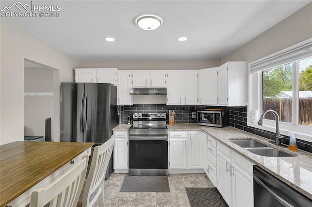 105 Easy St, Colorado Springs, CO 80911 - kitchen featuring stainless steel appliances, a sink, under cabinet range hood, light stone countertops, and white cabinets