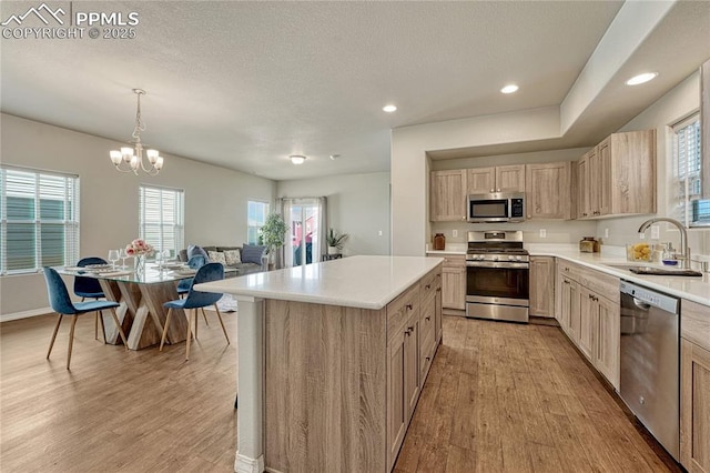 4342 Kaolin Ct, Colorado Springs, CO 80938 - kitchen featuring appliances with stainless steel finishes, light wood finished floors, light countertops, a chandelier, and light brown cabinets