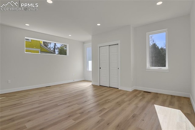 unfurnished bedroom featuring recessed lighting, light wood finished floors, baseboards, and a closet