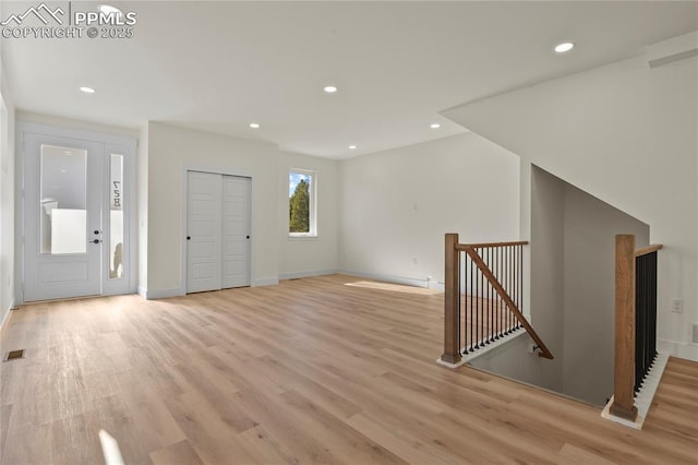 foyer featuring light wood finished floors, recessed lighting, and baseboards