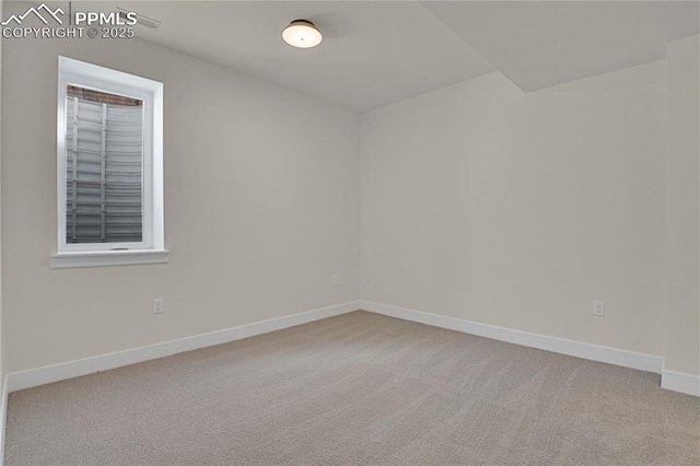 unfurnished room with light colored carpet and baseboards