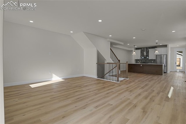 unfurnished living room with light wood-type flooring, recessed lighting, stairs, and baseboards
