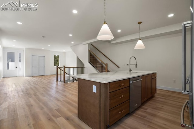 kitchen with a sink, wood finished floors, decorative light fixtures, recessed lighting, and baseboards