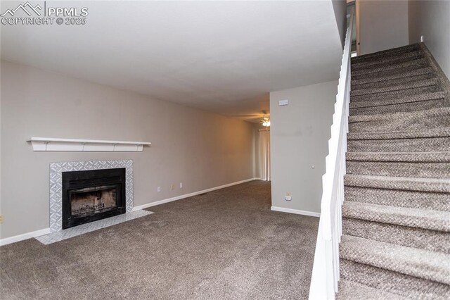 1295 Soaring Eagle Dr, Colorado Springs, CO 80915 - unfurnished living room with stairway, a tile fireplace, carpet flooring, a ceiling fan, and baseboards