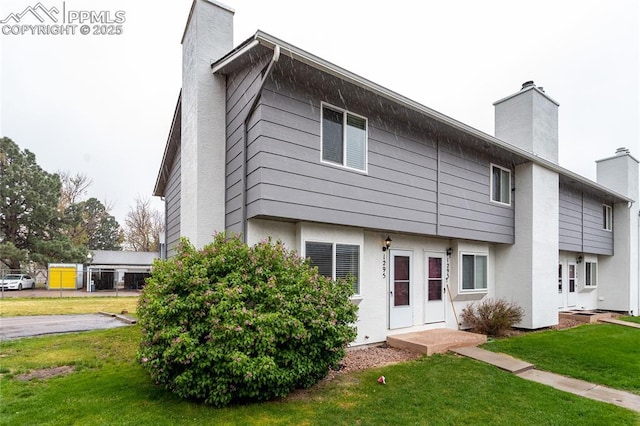 1295 Soaring Eagle Dr, Colorado Springs, CO 80915 - view of front of house featuring a chimney, a front yard, and stucco siding