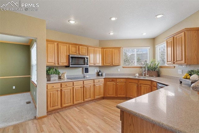 11985 Hanging Valley Way, Colorado Springs, CO 80921 - kitchen featuring stainless steel microwave, light wood finished floors, light countertops, recessed lighting, and a sink