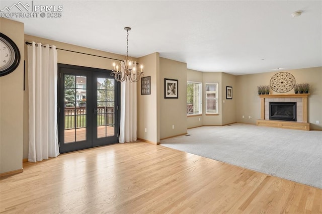 11985 Hanging Valley Way, Colorado Springs, CO 80921 - unfurnished living room featuring plenty of natural light, wood finished floors, a chandelier, and french doors