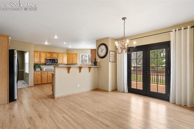 11985 Hanging Valley Way, Colorado Springs, CO 80921 - kitchen with stainless steel appliances, light wood-type flooring, a peninsula, healthy amount of natural light, and recessed lighting